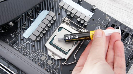 A hand applying thermal paste to a gaming CPU