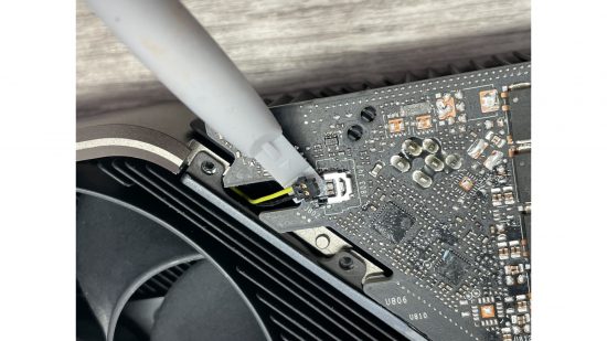 A plastic tool leveraging against the RTX 3080 GPU
