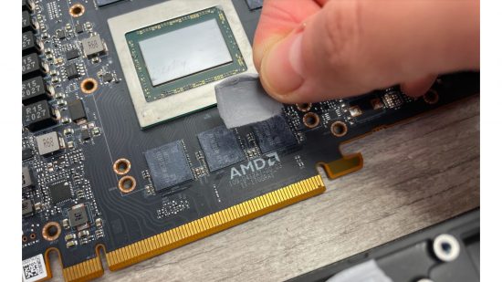 A hand replacing thermal pads on an AMD Radeon RX 6800 XT GPU