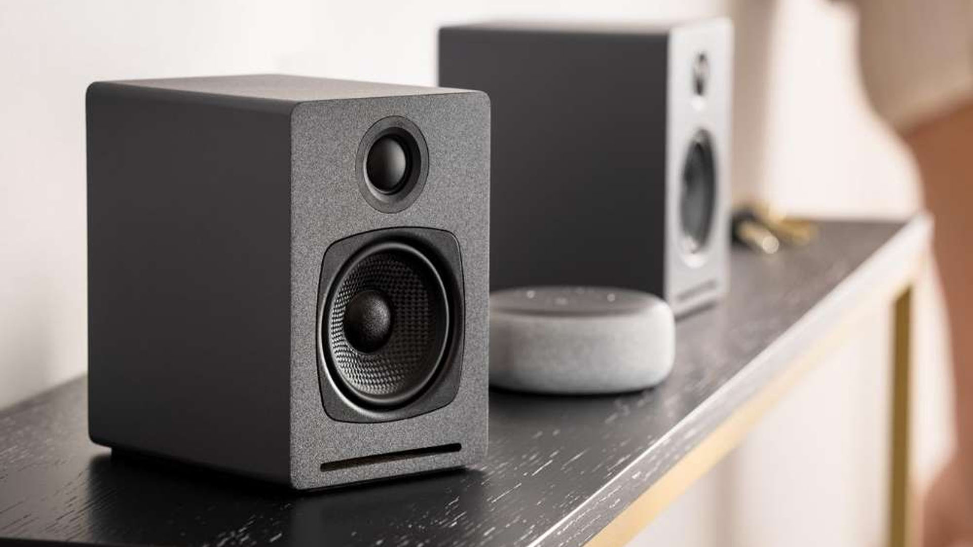 Audioengine A1 speakers next to Google Nest mini smart speaker