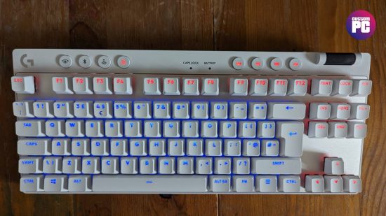 Logitech G Pro X TKL Lightspeed review: a white keyboard appears on a wooden worktop showing blue and orange RGB.